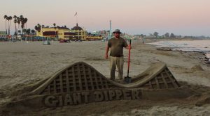 guy standing next to sand made giant dipper